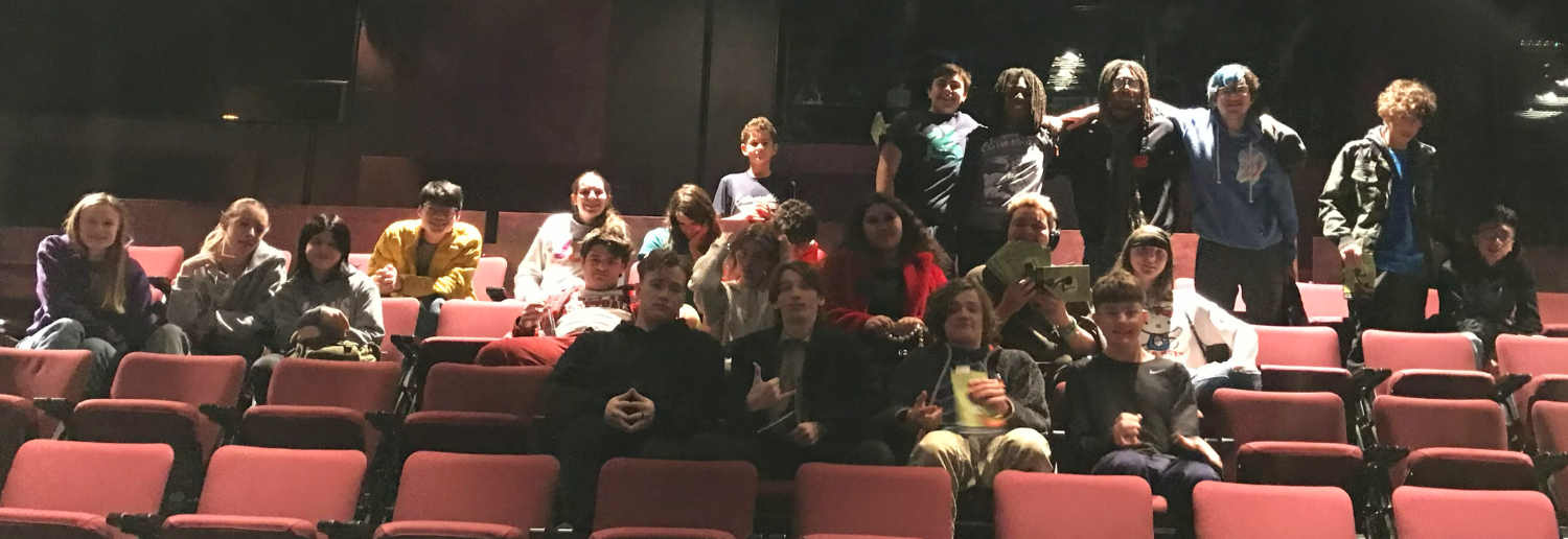 Baltimore Lab High School students sit in the audience with arms around each other at a theater performance.