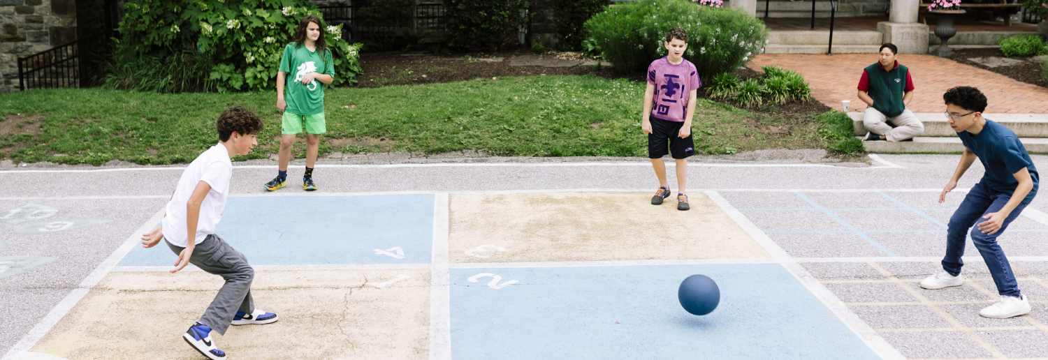 Baltimore Lab Middle School students play four square in the front play area.